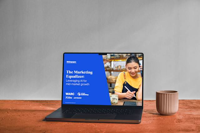 Laptop displaying "The Marketing Equalizer" whitepaper on blue background, with ceramic bowls on wooden surface
