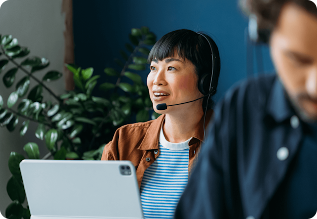 Image of a person sitting at a desk, on a call. The visual suggests how Mailchimp experts can help with template design, full-service campaign management, and more.