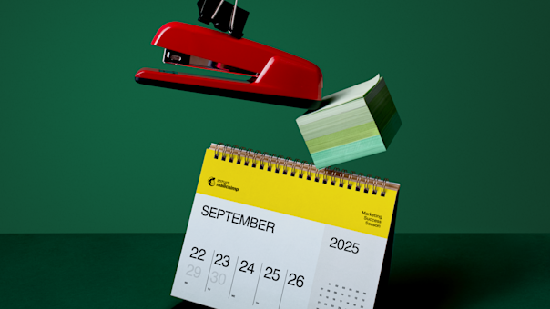 Calendario amarillo de Mailchimp que muestra las fechas de septiembre de 2025 sobre un fondo verde oscuro con clips de colores en la parte superior