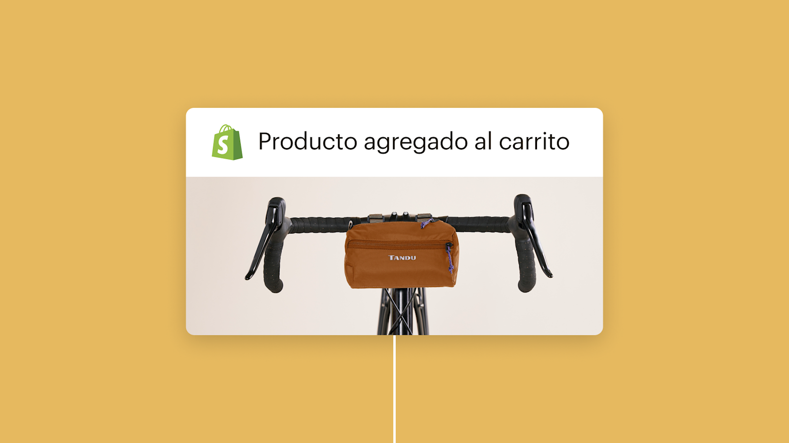 Bolsa con manija marrón montada en volantes de bicicleta negros con el logotipo de Shopify y el texto "Producto agregado al carrito" en inglés arriba